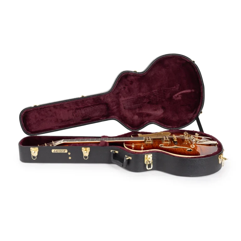 Gretsch G6136TGQM-59 Limited Edition Quilt Classic Falcon alojada en su estuche rígido original abierto, con interior de felpa color burdeos y acabado quilted en tonos ámbar y rojo, mostrando el instrumento y su sistema de protección para transporte.