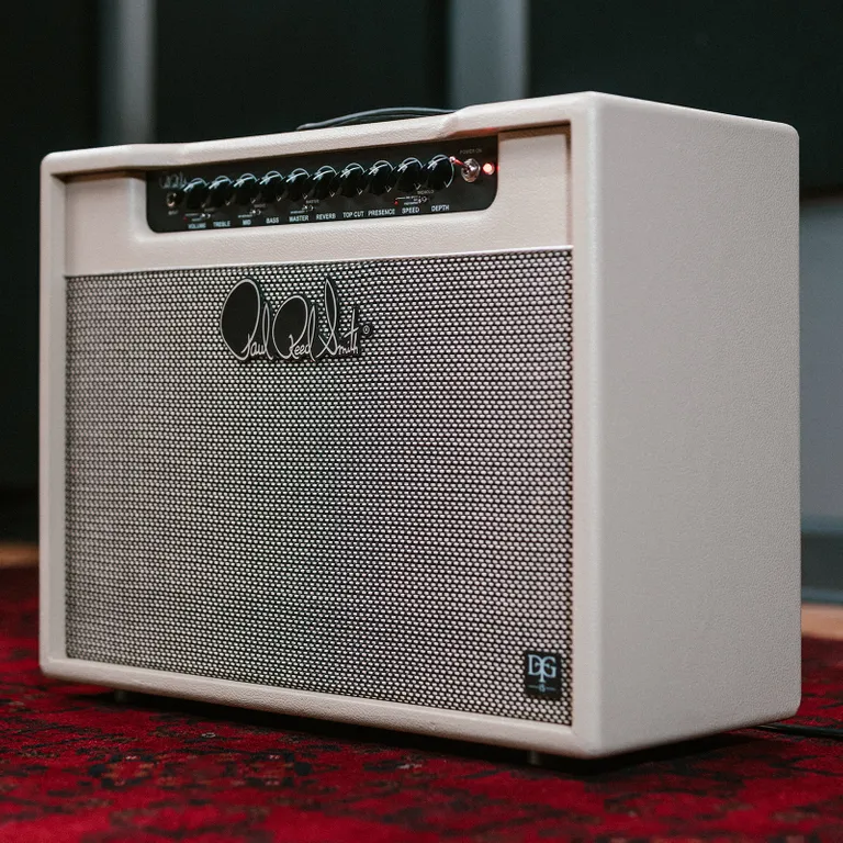 PRS DGT 15 Combo: análisis del combo de válvulas de 15 vatios de David Grissom 3 Amplificador de válvulas PRS DGT 15 Combo visto en perspectiva frontal, con acabado crema, panel superior de controles para ecualización, reverb y trémolo, rejilla frontal con el logotipo de Paul Reed Smith y diseño compacto para estudio y directo.