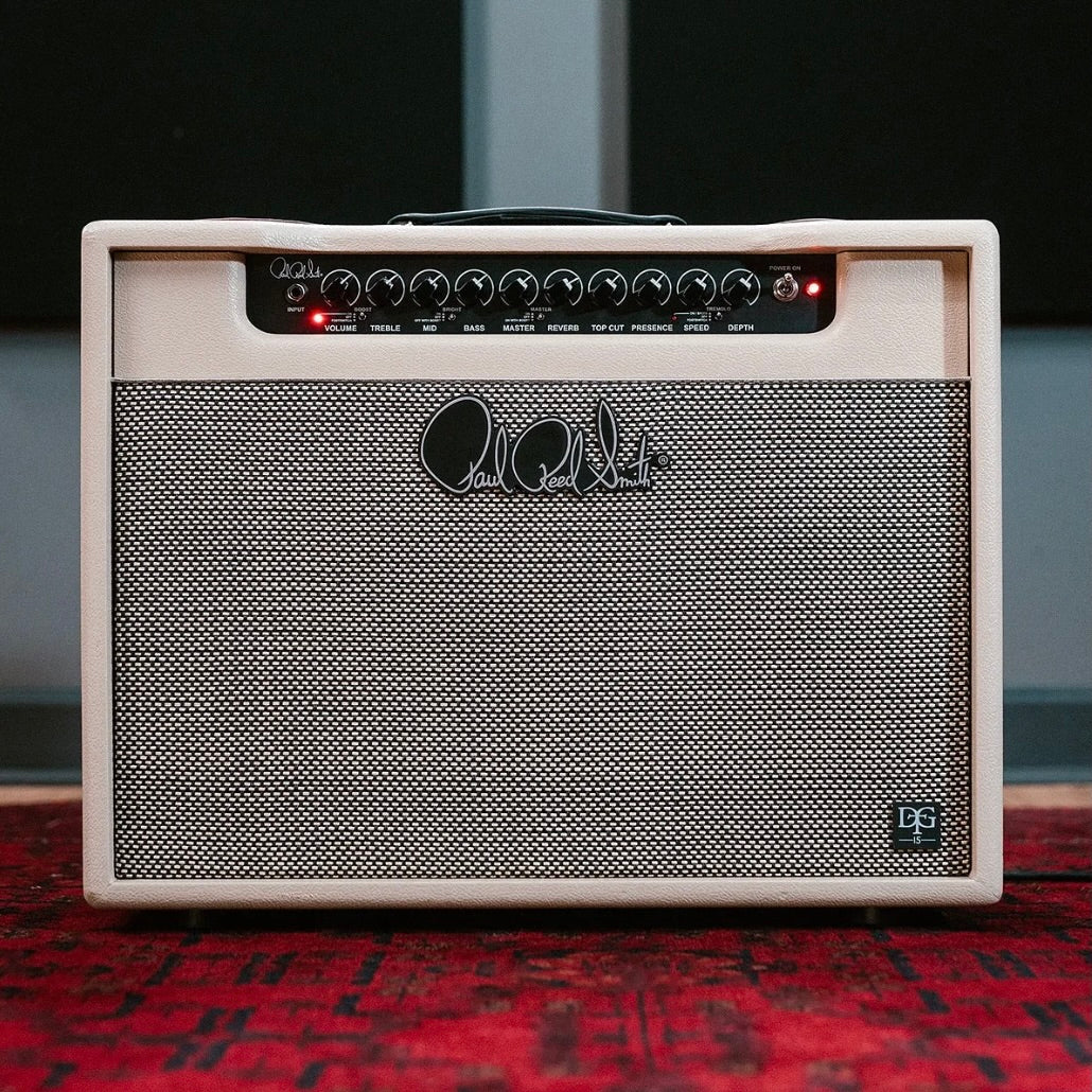PRS DGT 15 Combo: análisis del combo de válvulas de 15 vatios de David Grissom 1 Amplificador de válvulas PRS DGT 15 Combo con acabado en color crema, panel de control superior con ecualización de tres bandas, reverb y trémolo integrados, presentado sobre una alfombra roja en un entorno de estudio.