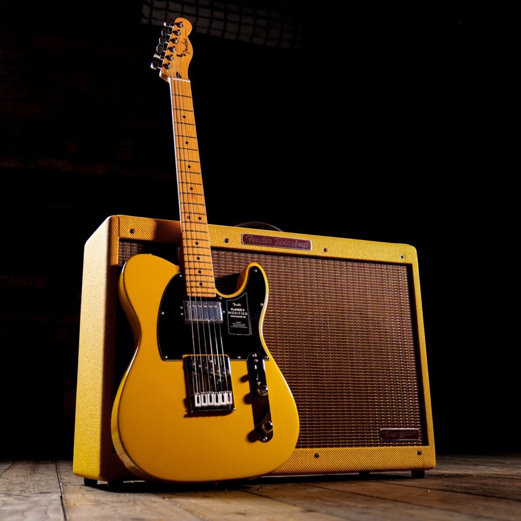 Fender Tone Master 59 Twin JB: análisis del primer amplificador digital firmado por Bonamassa 6 Guitarra Fender Player II Modified Telecaster en acabado amarillo Butterscotch apoyada frente a un amplificador Fender Tone Master '59 Twin Reverb JB Edition con revestimiento tweed, mostrando una configuración clásica de guitarra y amplificador para directo y estudio.