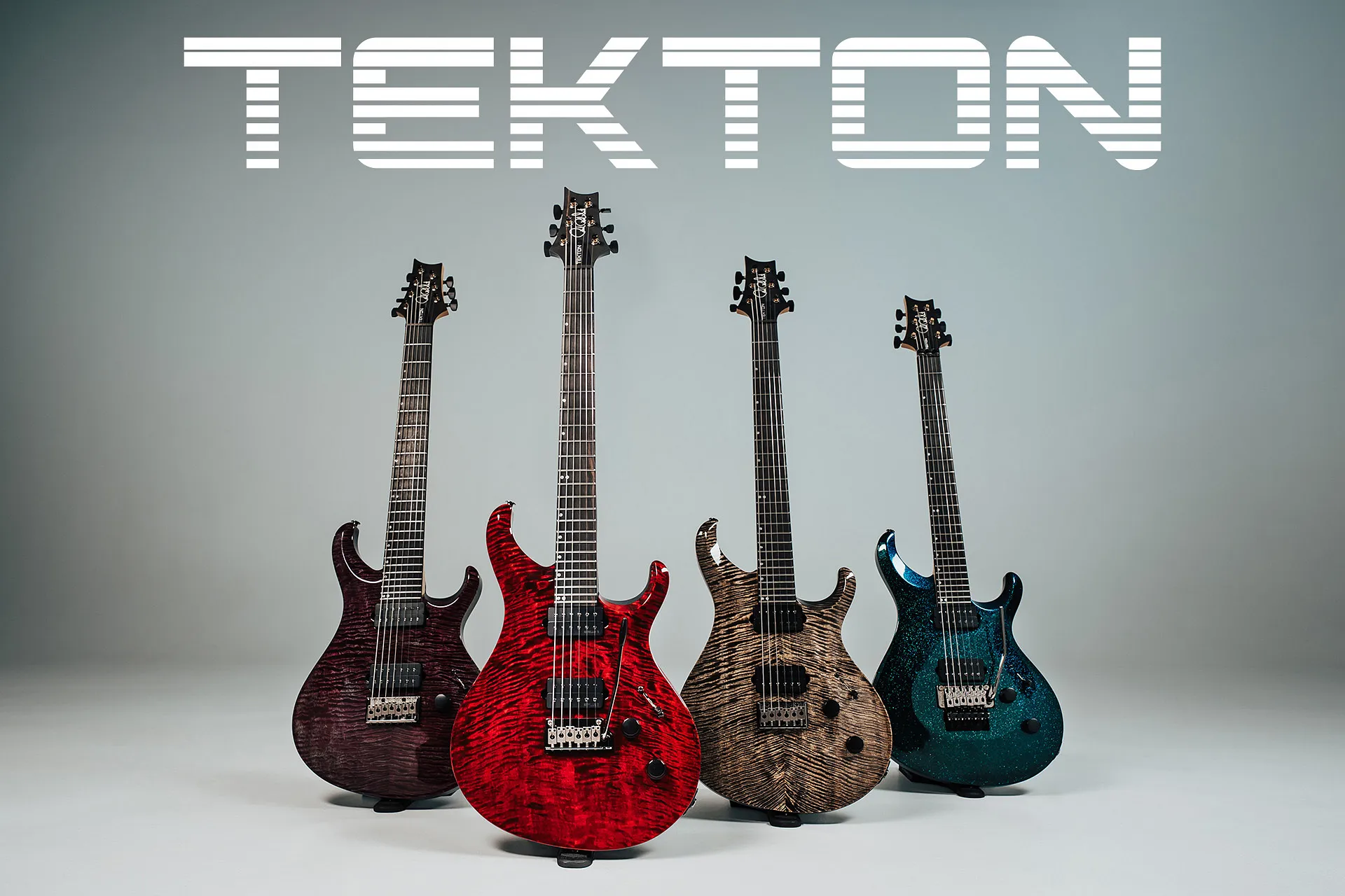 Cuatro guitarras de la gama PRS Tekton presentadas sobre fondo gris, con tapas de arce flameado en acabados morado, rojo, natural y azul, configuración de doble humbucker y diseño de doble cutaway, bajo el logotipo Tekton en una imagen promocional de la nueva serie.