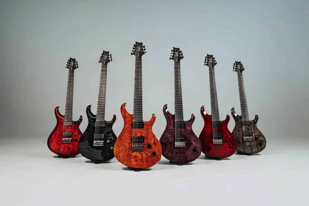 Colección de guitarras de siete cuerdas de la gama PRS Tekton SVN, mostrando seis modelos con tapas de arce figurado en distintos acabados translúcidos, configuración de doble humbucker, puente fijo y diseño de doble cutaway, desarrolladas para afinaciones extendidas y estilos modernos de alta ganancia.