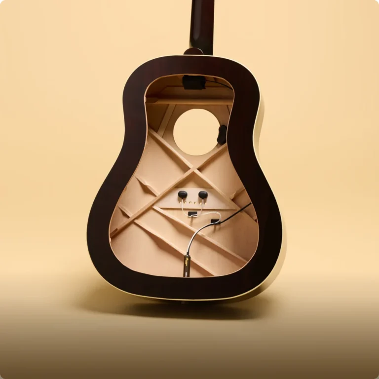 Interior de una guitarra acústica mostrando la instalación del sistema LR Baggs HiFi DNA, con dos sensores de captación adheridos a la placa del puente, cableado interno, preamplificador HiFi DNA y estructura de varetaje visible dentro de la caja de resonancia.