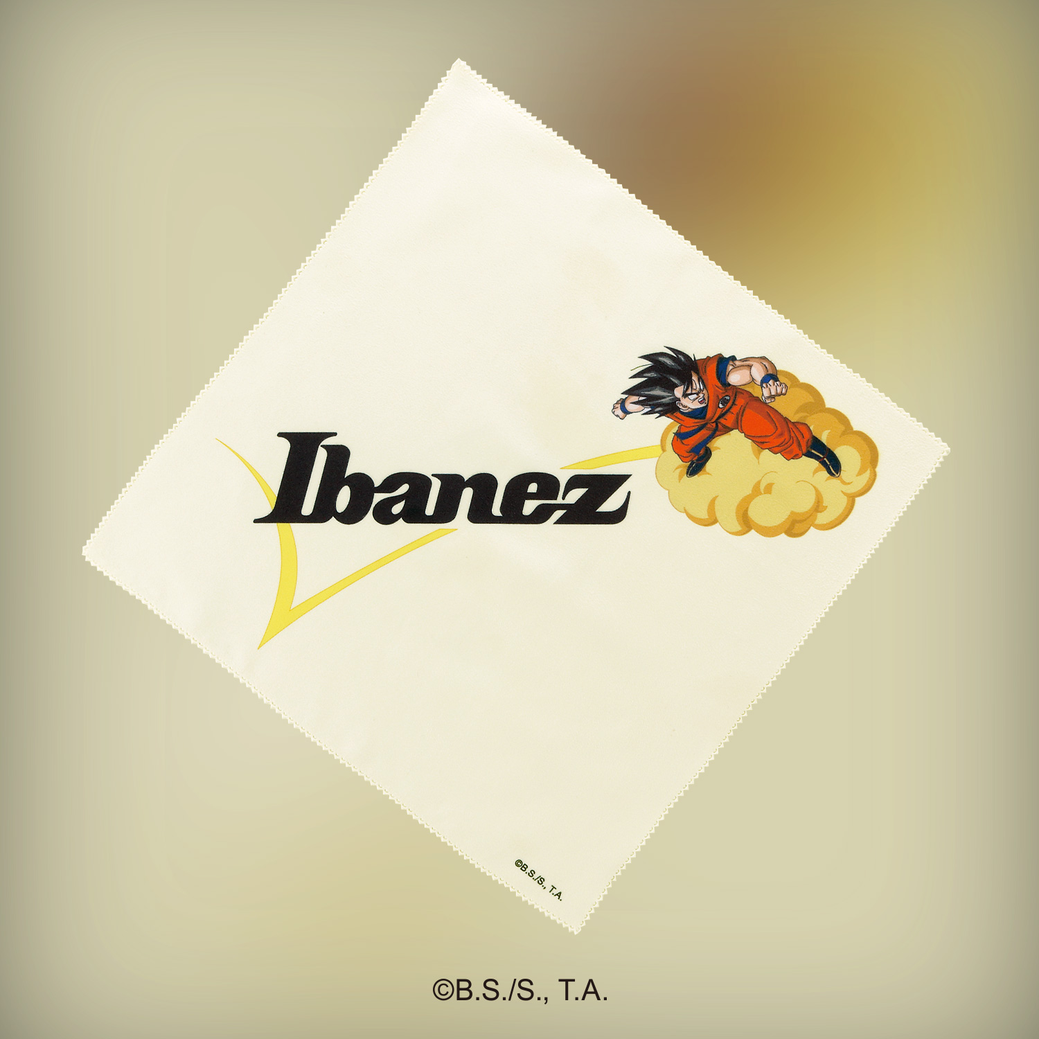 Ibanez Dragon Ball Z: análisis de la colección oficial que llegará en 2027 (RG japonesa, bajo, Tube Screamer y más...) 12 Paño de limpieza de microfibra de la colección Ibanez Dragon Ball Z Collaboration, decorado con el logotipo de Ibanez y una ilustración de Son Goku volando sobre la nube Kinton, diseñado como accesorio conmemorativo para guitarras y productos de la edición especial.