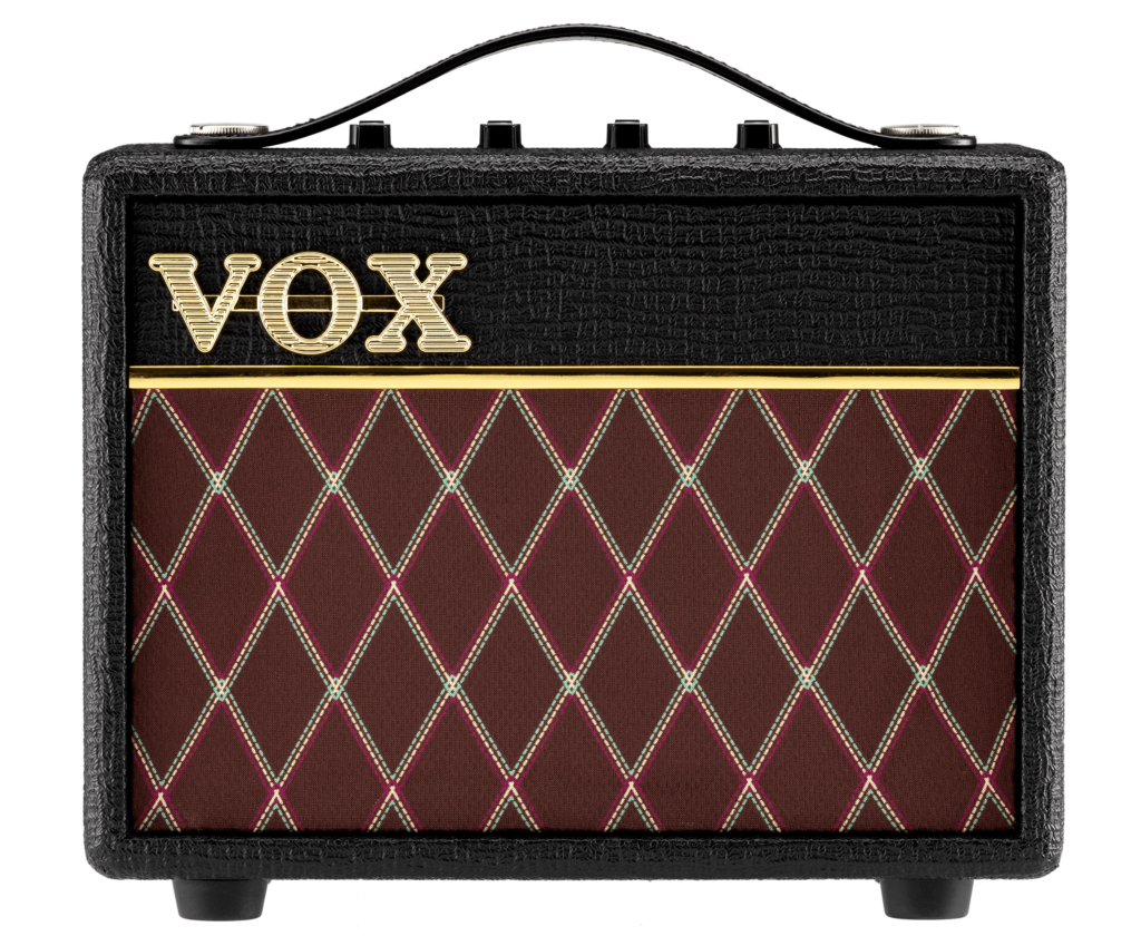 Vista frontal del amplificador portátil Vox AC Mini, con acabado negro texturizado, logotipo Vox en color dorado, rejilla frontal de diseño romboidal en tonos marrón y burdeos, asa superior de transporte y controles situados en la parte superior, sobre fondo claro.